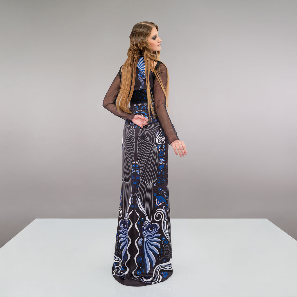 Full length multi-textured print dress featuring faux leather criss-cross paneling and black sheer sleeves. Semi-open top shoulders. Upper bodice has black with blue spotted design.