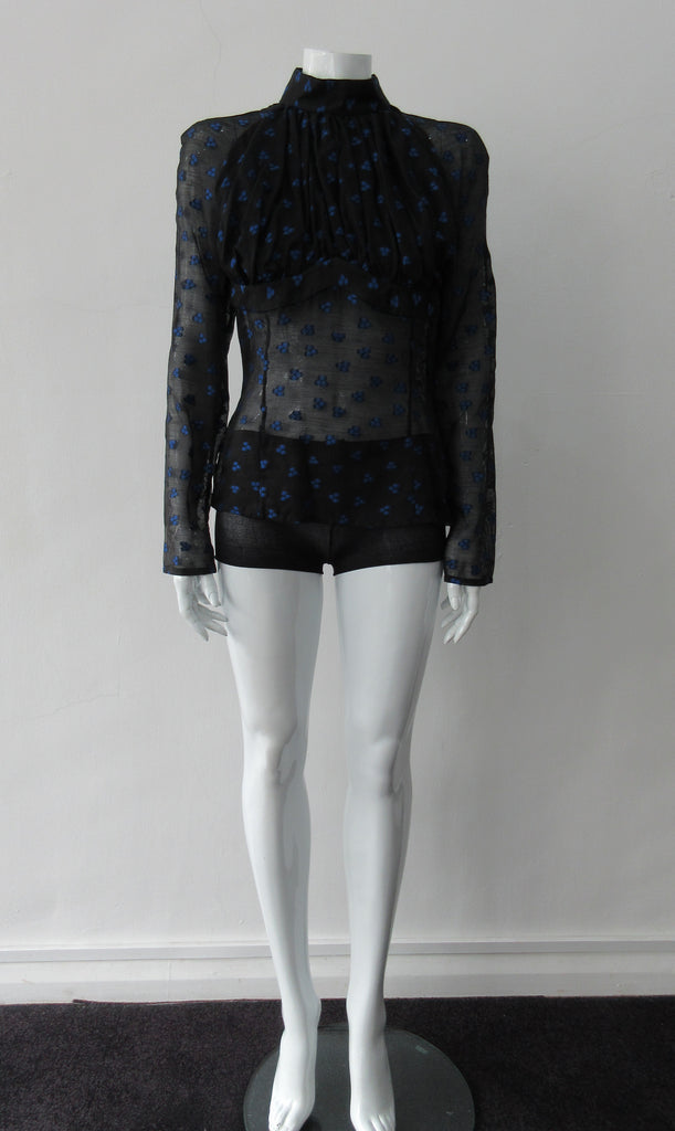 Dark Gathered Top, Generously gathered long sleve top in sheer black with tri-blue dot design. CB zipper and under bust panel trim. 2 invisible side zippers at side seam bottom. Can be paired with 180608D Dark Curve Front Pencil Skirt, CB length 60cm. 50g approximate weight 48% Polyester, 34% Cotton, 18% Nylon. Dry Clean Only. Made in England