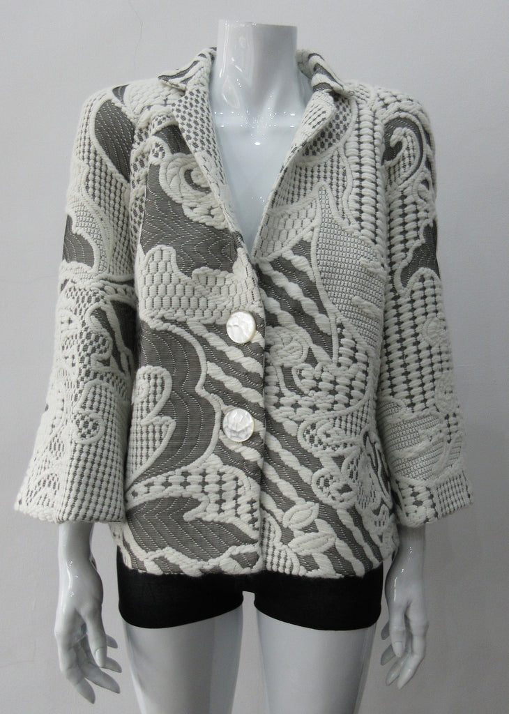 White Brocade Swing Jacket. Cropped full swing white multi textured brocade jacket. Contrast light grey undertone fabric. Including 2 beautiful buttons. CB length 55cm. 68% Polyamide, 29% Wool, 5% Silk Lining: 100% Rayon. Made in England