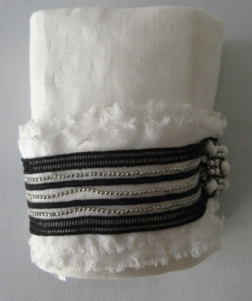 Catherine Osti White Linen with Stripe Trim Cuffs. 100% Unbleached Linen. Black & Silver stripe trim on base. Beaded Button top feature. Snap Closure. 19.5cm length snap to snap. 60g approximate weight, comes in white box. Made in France