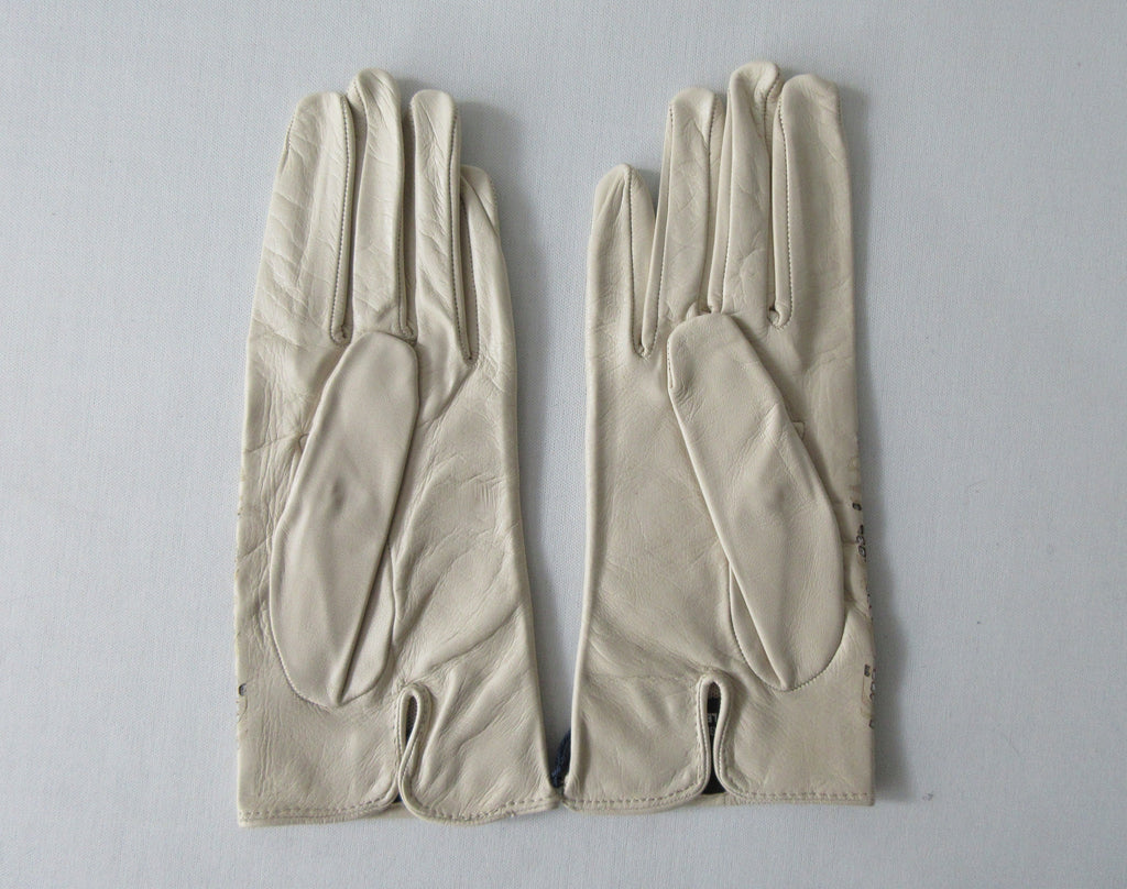 Tan Floral Cutout Gloves. Item Number D540NSF C1PRIA S357 0574. Tan Leather Gloves with floral cut-out design on top hand. 60g approximate weight. Made in Italy