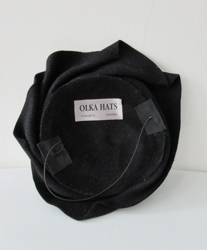 Olka Hats Black Felt Twirled Mini Black Felt Twirled with Black Rinestones, and elastic for chin. Retro style can be worn on top or side of head. 20cm x 21cm inside diameter. 30g approximate weight. Made in Canada