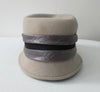 Olka Taupe Hat taupe colour felt with grey/black wrap around sash trim on brim. Size unknown, 57.5cm circumference. Height 12.5cm, Length 26.5cm, width 16.5cm. 26g approximate weight. 100% Wool. Made in Canada.