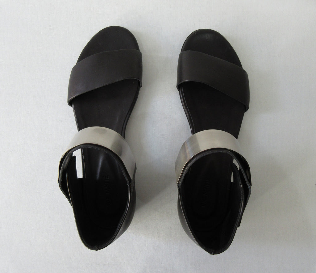 Vic Matie Flt Heel Metal Shin Shoe. Product Number: Vic Mate 1L5460D.L86L550101 Sandalo Alcazar 101 Black, 100% Leather with Stainless Steel Piece. Made in Italy