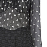 Medium length long sleeve dress featuring high ruched collar and gathered front bodice to waist panel. Sheer black with white tri-circular design. Slight fraying on collar natural part or ruching effect. Fully pleated below waist panel in solid black textured fabric. 700g approximate weight. 93% Acrylic, 7% Lycra. Contrast: 81% Polyester, 14% Polyamide, 5% Elastine. Dry Clean Only.  Made in England
