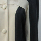 Full length coat featuring charcoal and white contrast panels. 5 covered buttons on centre front.